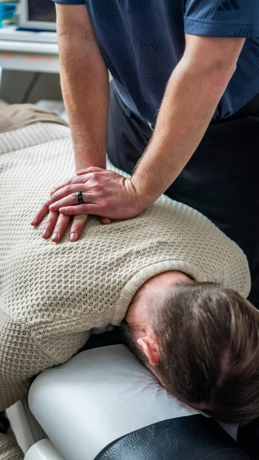 Chiropractor adjusting patient's upper back and neck