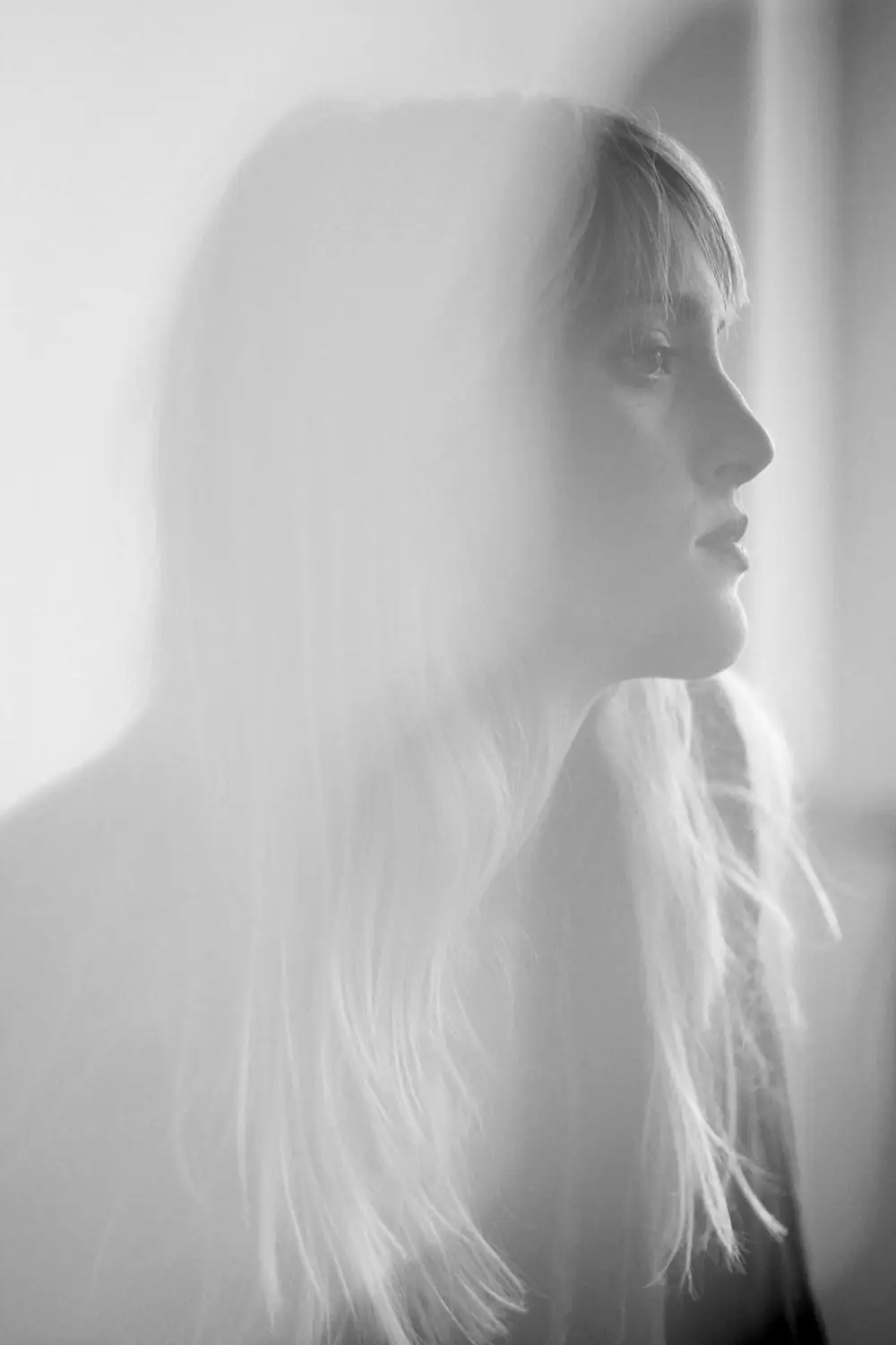 A woman is seen in a soft, black and white portrait